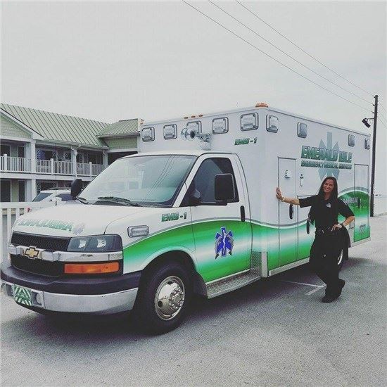 EMS staff member with hand on ambulance