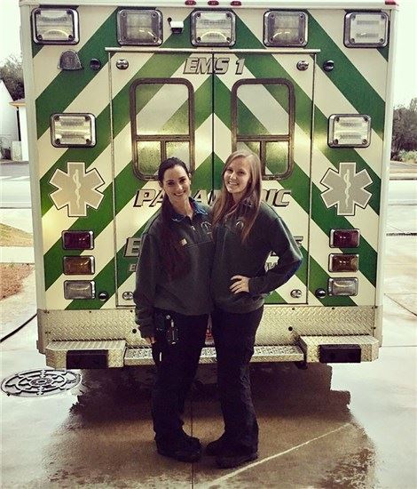 EMS staff posing at the rear of an ambulance