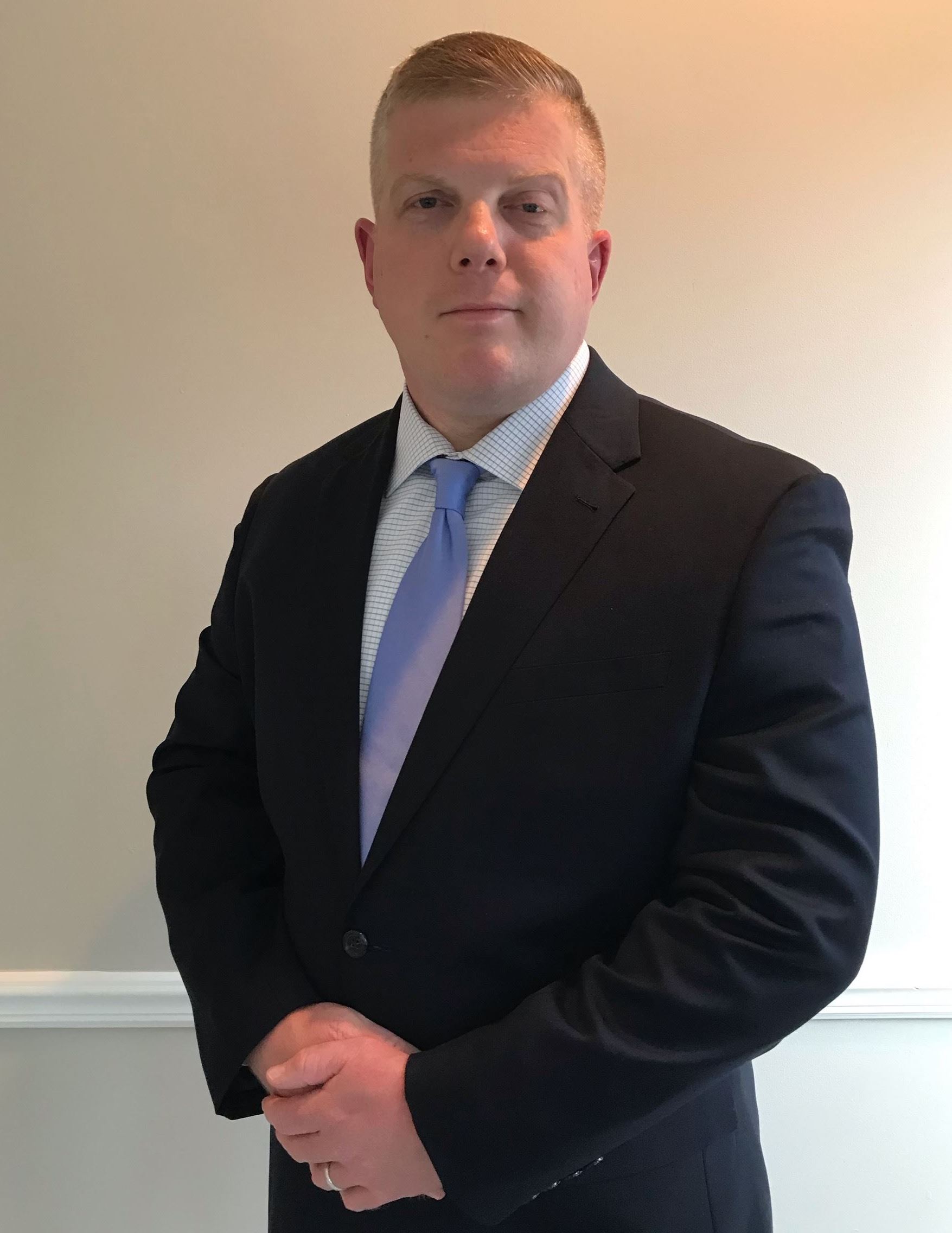 Man wearing a black suit with purple tie
